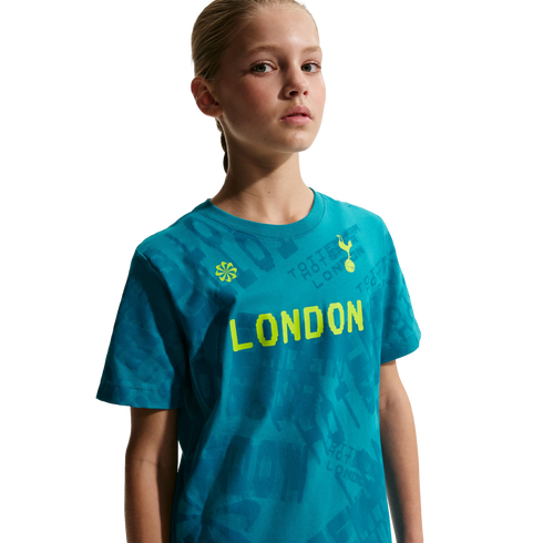 Young girl wearing a teal T-shirt with "LONDON" in neon yellow and the Tottenham Hotspur logo, against a black background.