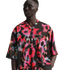 Man wearing a vibrant Nike Air jersey with a colorful abstract halftone pattern and white logo outline. Plain white background.