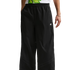 A person wears black wide-leg Nike Air trousers with thin grey curved piping around the knees.
