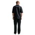 Back view of a man wearing a black jersey with "NORGE" across the upper back and black sweatpants, standing against a white background.