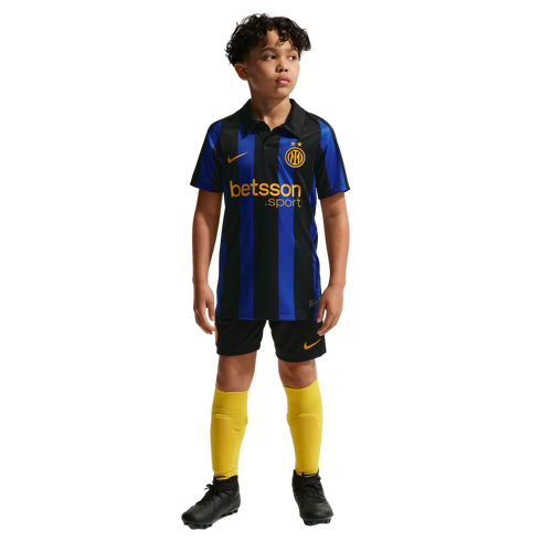 A young boy posing in a blue and black striped Inter Milan soccer jersey, black shorts, yellow socks, and black cleats on a plain white background.