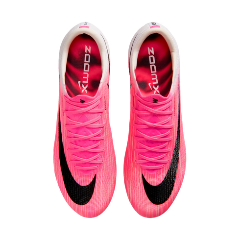 Top-down view of bright pink Nike soccer cleats on a white background. Each shoe features a large black swoosh, pink laces, and "ZOOMX" printed on the inner sole.