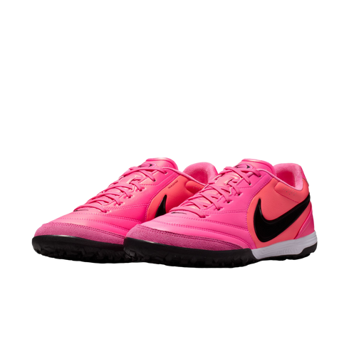 Bright pink Nike turf soccer shoes with a black swoosh and black soles on a white background.