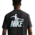 Rear view of a person wearing a dark t-shirt with a large light blue graphic of a stylized soccer player kicking a ball above the word "NIKE."