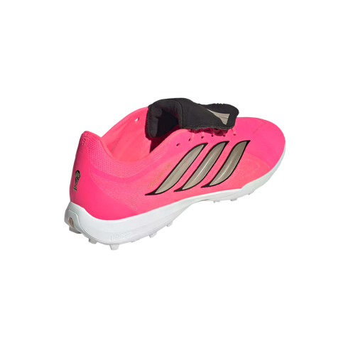 Three-quarter rear view of a bright pink Adidas soccer shoe with silver stripes, a black fold-over tongue, and a white studded sole against a plain white background.