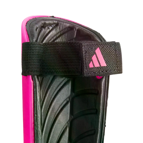 Close-up of a pink Adidas shin guard showing the black padded interior and an elastic strap with a pink logo.