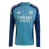 Light and dark blue Adidas Arsenal training top with a quarter-zip. Features the club crest, Adidas logo, and "Emirates FLY BETTER" sponsor.