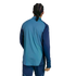Rear view of a person with braided hair wearing a two-tone blue athletic long-sleeve top and matching pants against a solid black background.
