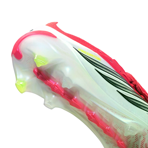 Close-up of an Adidas Predator soccer cleat's translucent white soleplate featuring lime green studs and a red central power spine.