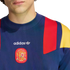 Close-up of a navy blue Adidas sweatshirt with red and yellow shoulder panels and the Spanish national football team crest on the chest.