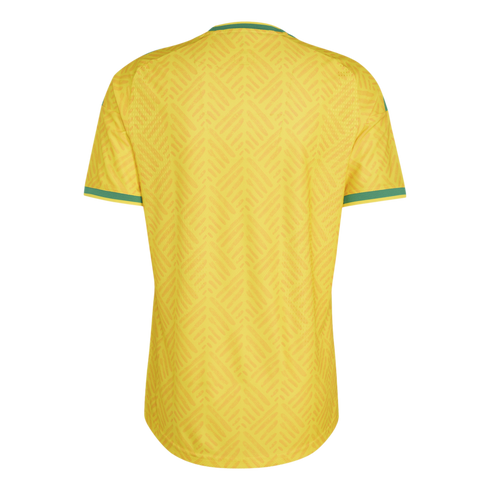 Back view of a yellow soccer jersey with green trim on the collar and sleeves, featuring a subtle, repeating tonal zig-zag pattern.