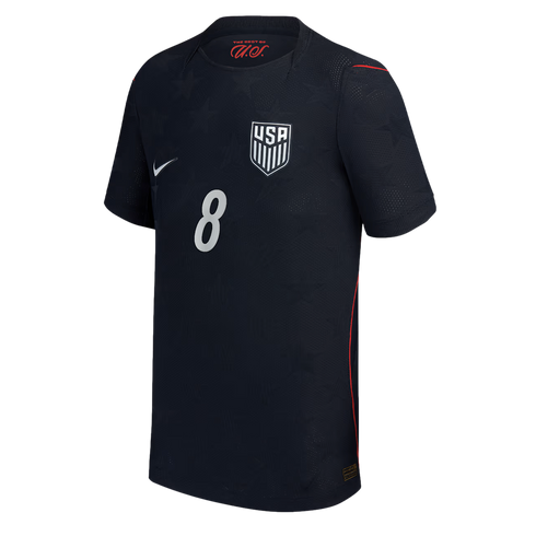 A dark blue USA national team soccer jersey featuring a large white number 8 centered on the front. The jersey includes a white Nike swoosh on the right chest, the USA soccer crest on the left, and subtle embossed star patterns throughout the fabric with